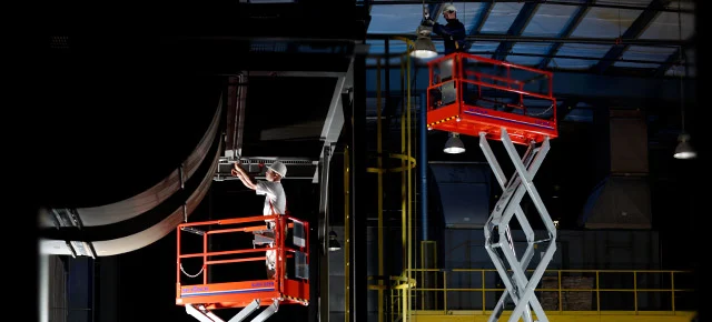 Zwei Scherenarbeitsbühnen im Einsatz in einer Halle